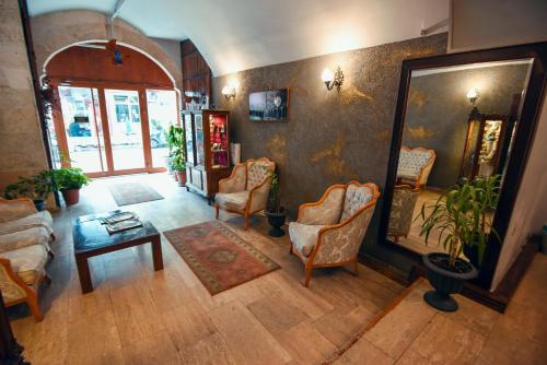 埃迪尔内埃迪尔塔山酒店的客厅配有椅子、桌子和镜子