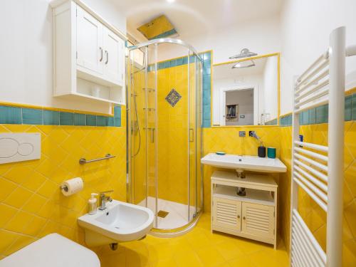 波西塔诺Artist House in Positano的黄色的浴室设有水槽和淋浴