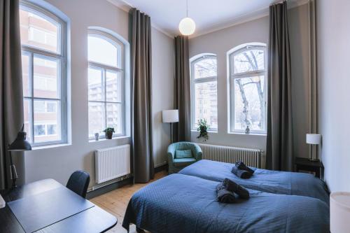 哥德堡Holterman Hostel的一间卧室设有蓝色的床和2个窗户。
