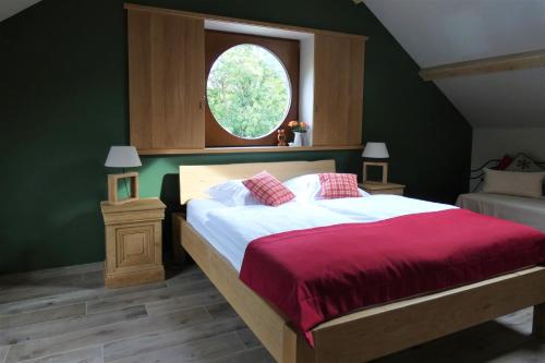 珀潘斯特尔Un air de bourlingueurs的一间卧室配有一张带红色毯子的床和窗户。