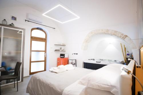 奥斯图尼Ostuni Luxury Room的白色卧室配有一张床和炉灶