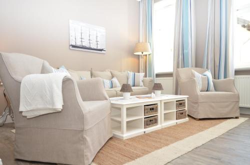 奥斯赛拜-塞林Villa Fernsicht - Apt. 04的客厅配有两把椅子、一张沙发和一张桌子