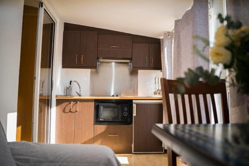 普拉森西亚格耶思科广场旅馆的厨房配有木制橱柜和桌椅