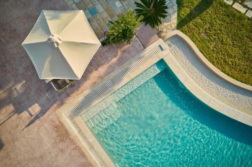 蒂锡利维爱奥尼亚奥拉酒店的游泳池顶部景,带遮阳伞