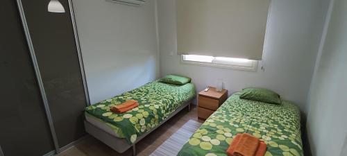 皮尔瓦利亚Sunrise Villa的小房间设有两张床和窗户