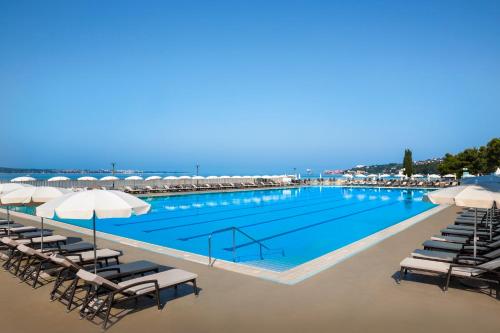 波尔托罗Remisens Hotel METROPOL的一个带躺椅和遮阳伞的大型游泳池
