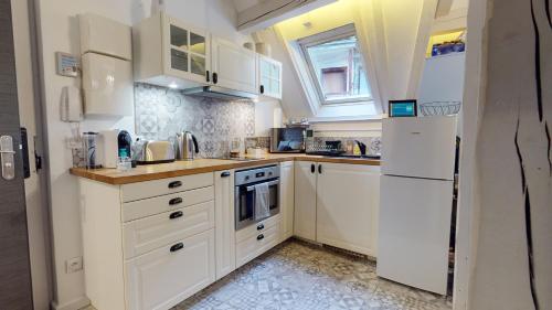 斯特拉斯堡LE NID DE L'ILL, Magnifique Duplex Cosy Petite France的厨房配有白色橱柜和白色冰箱。