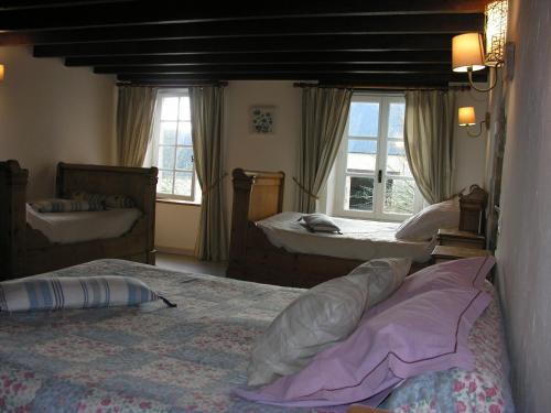 La CambeFerme de Savigny的一间卧室设有两张床、两个水槽和窗户。