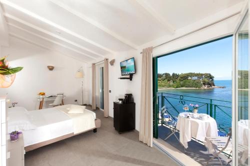 圣托斯特凡诺港多米希亚别墅酒店的一间卧室设有一张床和一个美景阳台