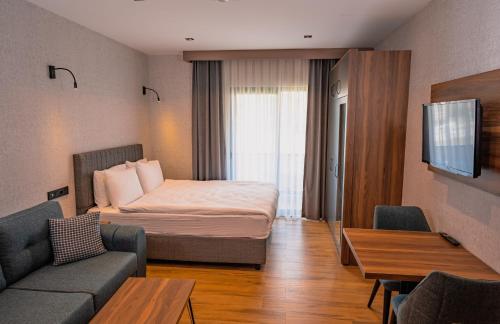 伯萨Görükle Alpaş Yaşam Hotel的酒店客房,配有床和沙发