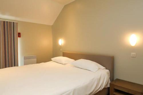 弗罗夏佩勒Villa 2 chambres au bord du lac de l'Eau d'Heure的卧室配有一张带两个枕头的大白色床