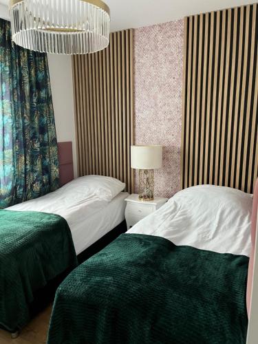 ZblewoApartament Złoty 3的一间卧室配有两张床和吊灯。