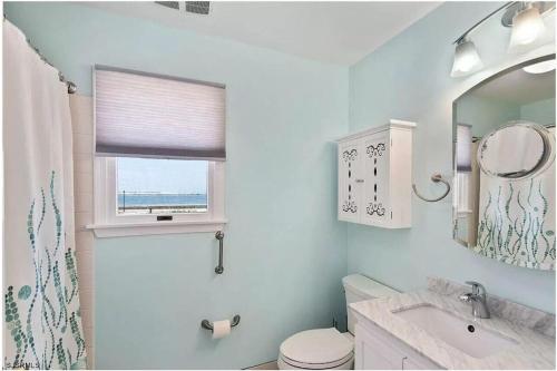 大西洋城3 bedroom Atlantic City House Steps from Boardwalk, beach, shopping , nightlife.的一间带水槽和卫生间的浴室以及窗户。