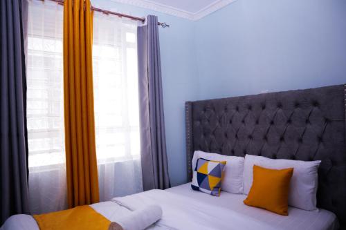 Langata RongaiSpringStone executive suite Rm 18的一间卧室配有一张带床头板的床和窗户