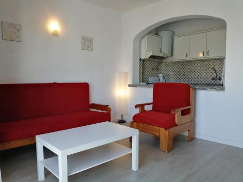 阿尔布费拉Oura Parque Apartamentos Turisticos的客厅配有红色沙发和红色椅子