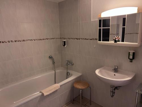 奥伊宾海恩金福斯旅馆及餐厅的浴室配有盥洗盆、浴缸和盥洗盆
