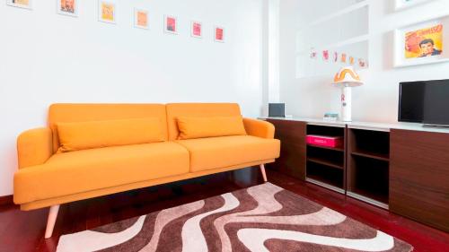 塞格拉泰Italianway - Nona Strada 7的客厅里设有一张橙色沙发,配有电视