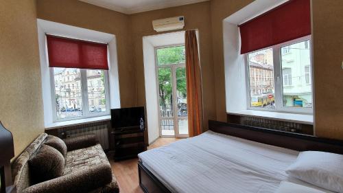 利沃夫Apart-Hotel City Center Contrabas的一间卧室配有一张床、一把椅子和窗户。