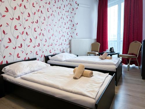 布拉迪斯拉发莫德纳酒店的红色和白色壁纸客房内的两张床