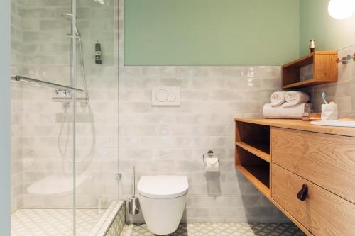 菲拉赫harry's home hotel & apartments的一间带卫生间和玻璃淋浴间的浴室