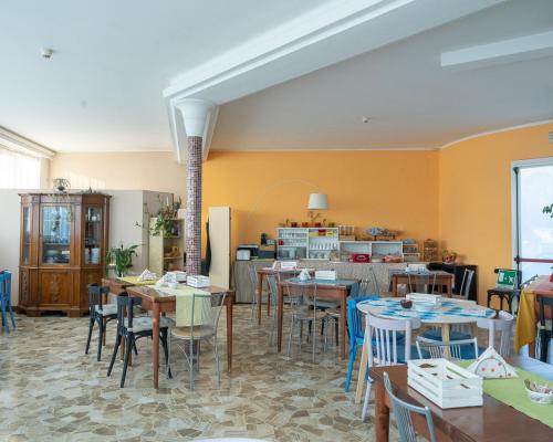 帕埃塞Hotel all'Oasi的一间带桌椅的用餐室和一间厨房