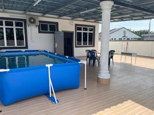 波德申cuti-cuti port dickson homestay的庭院内一个带桌椅的游泳池