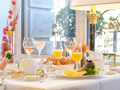 苏黎世The Dufour by Hotel Schweizerhof Zürich的一张桌子,上面放着一盘食物和酒杯