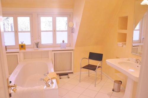 不来梅港Apartment am Bürgerpark的带浴缸、水槽和椅子的浴室
