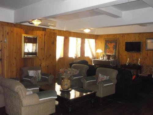KeimoesKeimoes Hotel的带沙发和椅子的客厅以及木墙