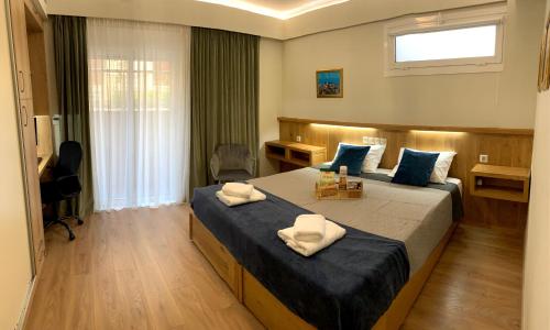 罗德镇A&B Rhodes city apartments的一间卧室设有两张床、一张桌子和一个窗口。