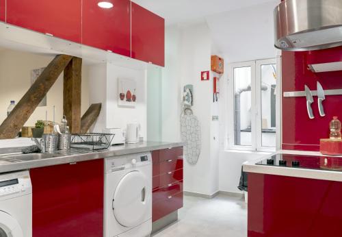 里斯本262 Baixa Guesthouse的一间带红色橱柜和洗衣机的厨房