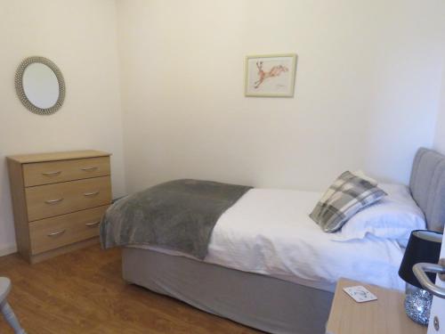 巴里Beautiful 3-Bed Cottage in Llancarfan Nr Cardiff的一间卧室配有一张床和一个梳妆台