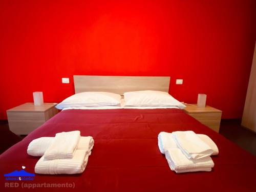 那不勒斯About Toledo的红色卧室,配有带毛巾的床