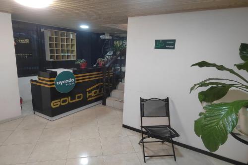 波哥大Ayenda Gold House的墙上有标志的房间和椅子