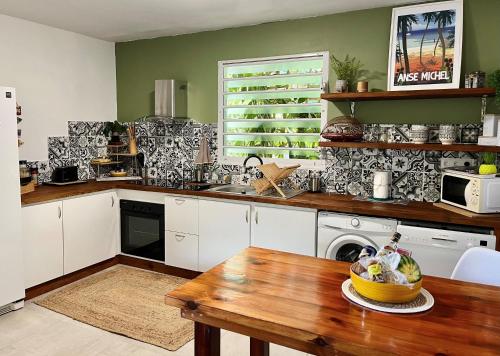 莱特鲁瓦西莱Ti Kay Ilets的厨房配有白色橱柜和木桌