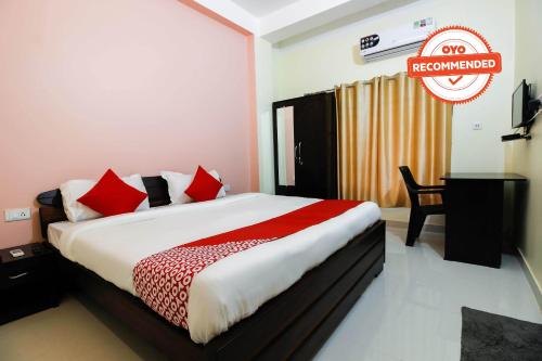 DispurAditya Guest House的一间卧室配有一张带红色枕头的大床