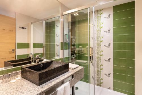 莱斯卡尔Best Western Hotel & SPA Pau Lescar Aeroport的一间带两个水槽和玻璃淋浴间的浴室