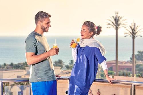 吉达فندق مروج نجد的男人和女人站在阳台上喝饮料