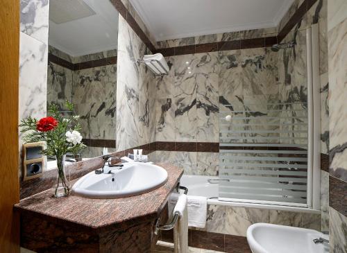 萨莫拉泽尼特两公主酒店的一间带水槽和浴缸的浴室
