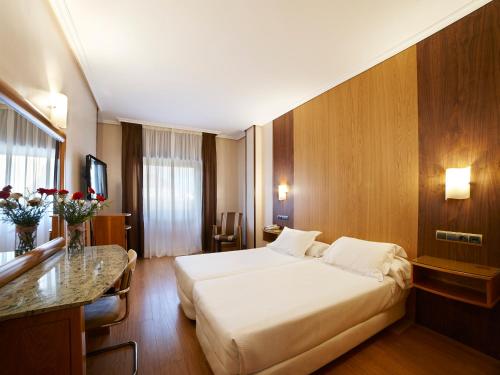 萨莫拉泽尼特两公主酒店的酒店客房设有一张大床和一张书桌。