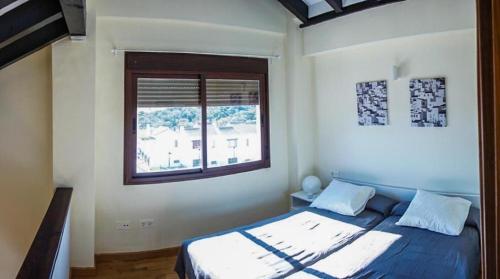 塞维利亚Casa Rural El Olivar的一间卧室设有一张床和一个窗口