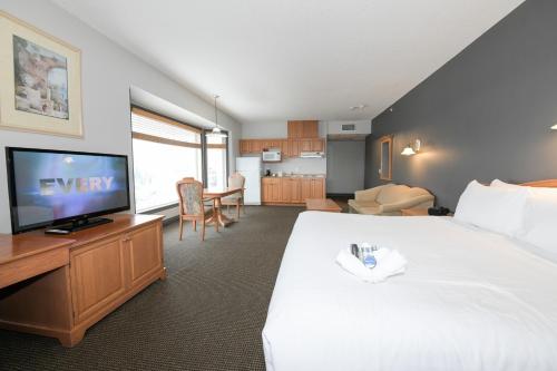 麦克默里堡Prime Hotel的一间酒店客房,配有一张大床和一台平面电视