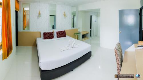 合艾The Train Hotel Hatyai的一间卧室配有带白色床单和红色枕头的床。