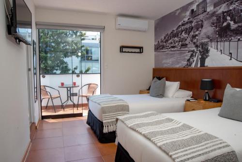 利马Lima 18 Boutique的酒店客房设有两张床和一个阳台。