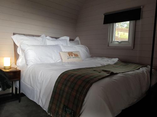 DunbeathDunbeath Coastal Retreat的卧室配有白色的床,上面有狗枕