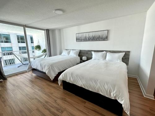 迈阿密City & Sea View+FREE Parking Modern Condo的一间卧室设有两张床和大窗户