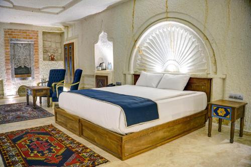 内夫谢希尔Cappadocia Sweet Cave Hotel的一间卧室设有一张大床和拱形窗户