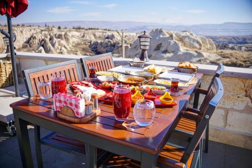 内夫谢希尔Cappadocia Sweet Cave Hotel的一张桌子,上面放着食物和饮料,享有美景