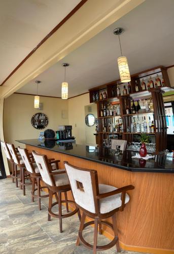 圣维森特Foxy's Beach Resort的餐厅内的酒吧配有椅子和柜台