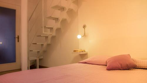 卡利亚里Appartamento Lilla dei Buoni e Cattivi的一间卧室设有一张床和一个螺旋楼梯